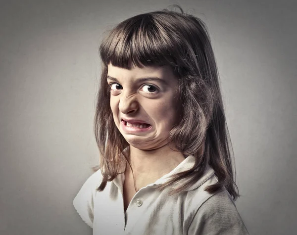 La niña está haciendo una mueca. — Foto de Stock