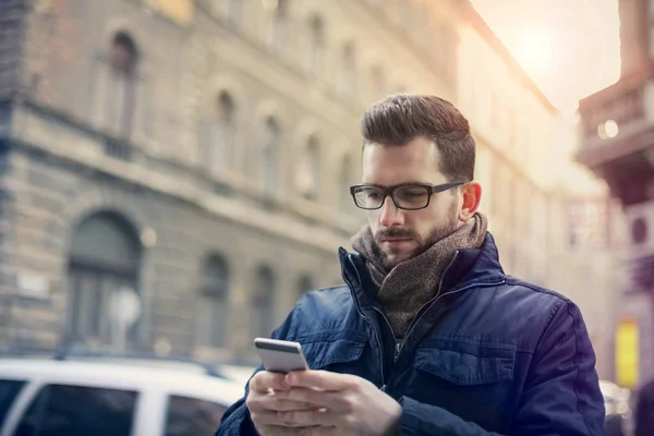 El joven está enviando mensajes en la calle — Foto de Stock