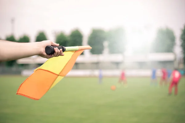 Arbitre tenant un drapeau jaune sur le terrain — Photo