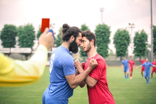 2 jogadores de futebol que têm um argumento em campo — Fotografia de Stock