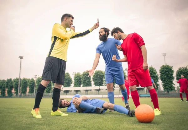 Scheidsrechter en voetbal spelers die een argument — Stockfoto