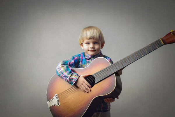 Malé dítě s velkými akustická kytara — Stock fotografie