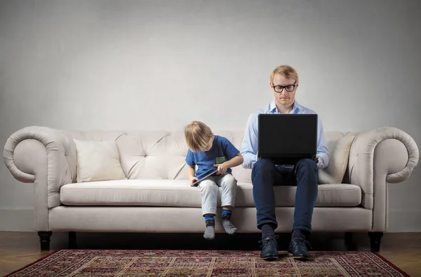 Man aan het werk naast zijn kind — Stockfoto