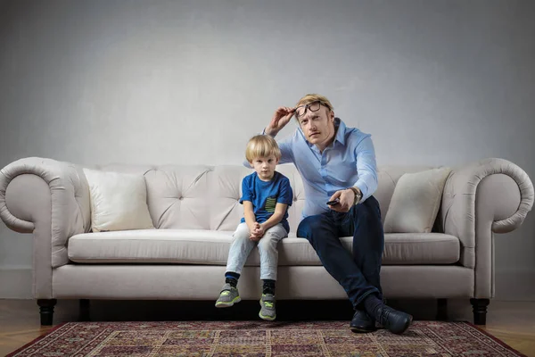 Vader en zoon kijken Tv vanaf de Bank — Stockfoto