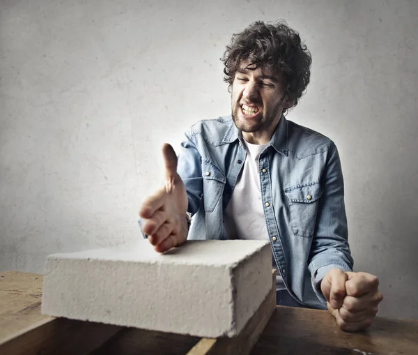 Man probeert te remmen van baksteen met zijn handen — Stockfoto