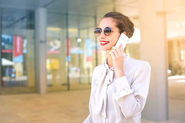 Stijlvolle vrouw in zonnebril bellen — Stockfoto