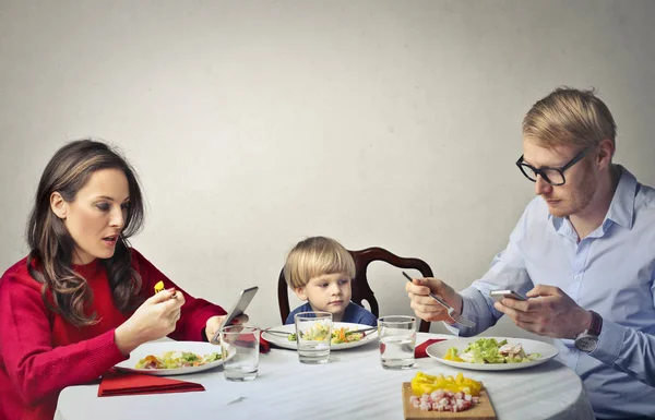 Rodzice, ignorując ich dziecka na stół — Zdjęcie stockowe