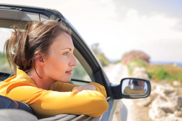 Woman looking out of  car in the nature — Stock Photo, Image