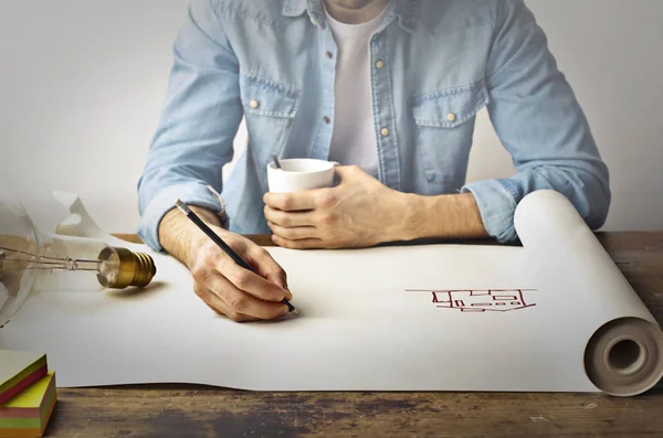 Мужчина рисует дом на бумаге — стоковое фото