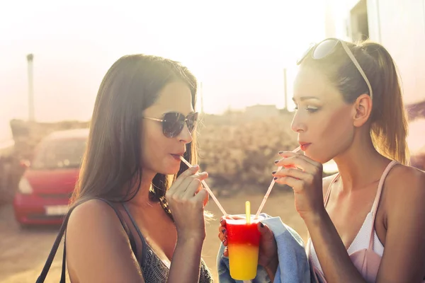 2 giovani donne che bevono dalla tazza — Foto Stock