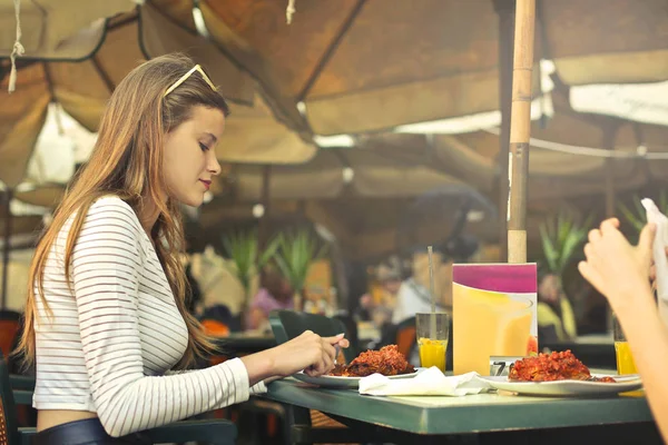 Ung kvinna äter i restaurang — Stockfoto