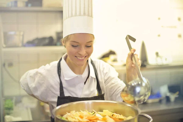 Vrouw van de chef-kok koken voedsel in keuken — Stockfoto