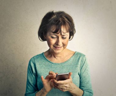 Yaşlı kadın akıllı telefonunu kullanarak