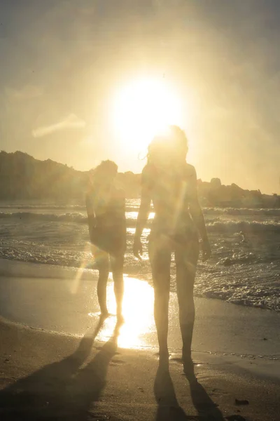 2 mulheres na praia ao pôr do sol — Fotografia de Stock