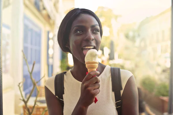 Zwarte vrouw eten van ijs buiten — Stockfoto