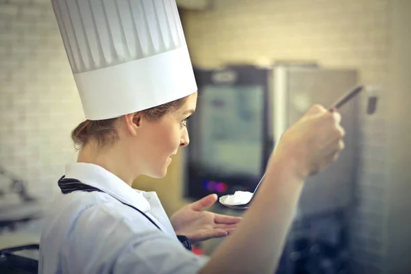 Chef femmes dégustation sa propre nourriture — Photo