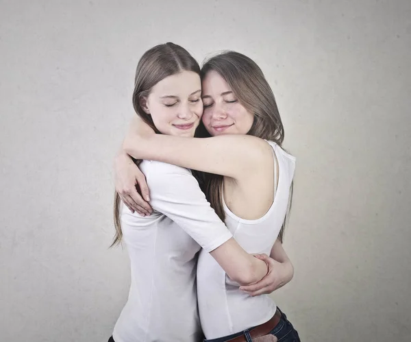 2 junge Frauen umarmen sich im Inneren — Stockfoto