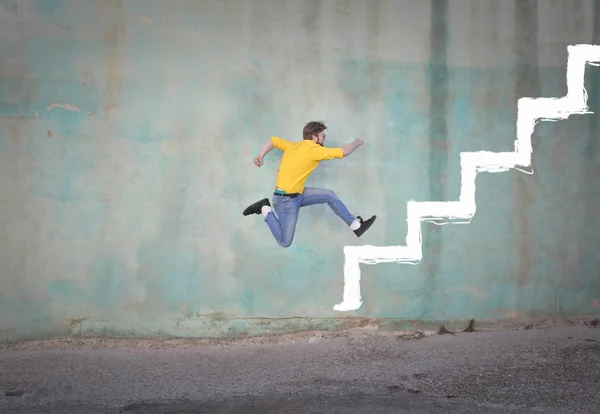 Mann springt auf gezogene Treppe — Stockfoto