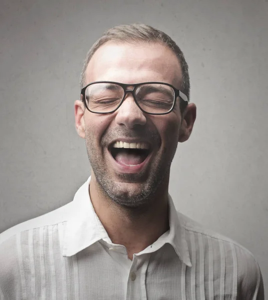 Young businessman with glasses laughing inside — Stock Photo, Image