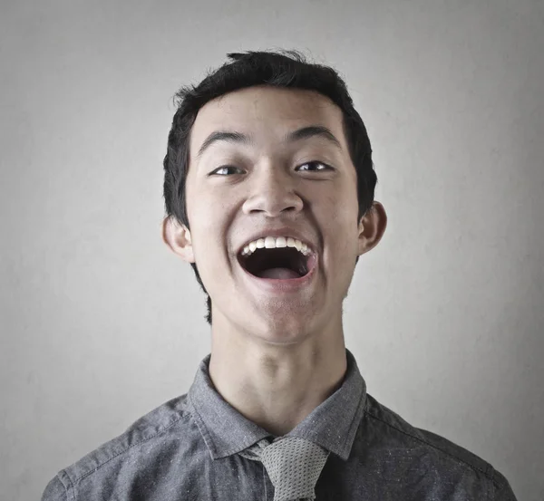 Young asian man laughing inside room — Stock Photo, Image