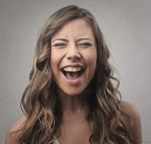 Young brunette woman laughing inside — Stock Photo, Image