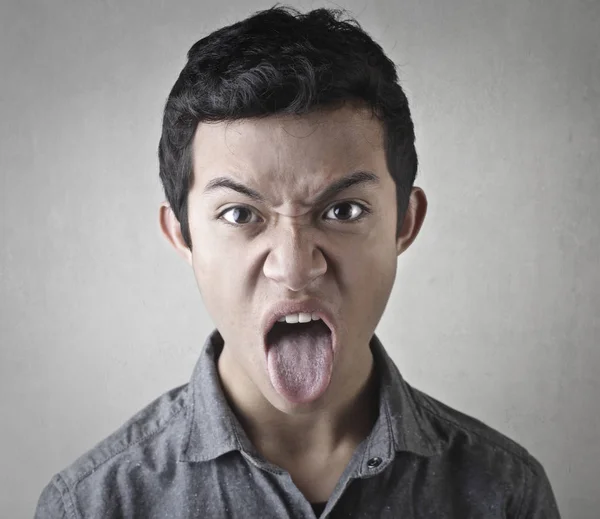 Asiático hombre sticking su lengua fuera —  Fotos de Stock