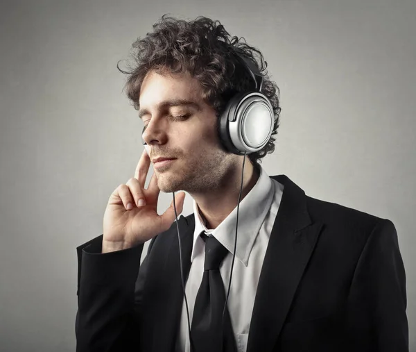 Jovem empresário ouvindo música — Fotografia de Stock