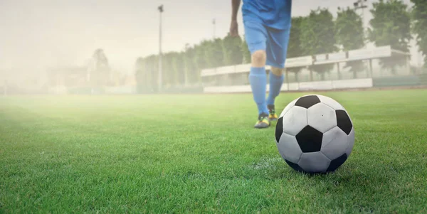 Jogador de futebol caminhando em direção a bola de futebol — Fotografia de Stock