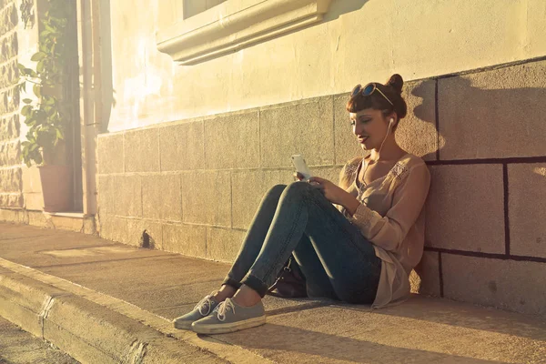 Jovem mulher sentada na cidade — Fotografia de Stock