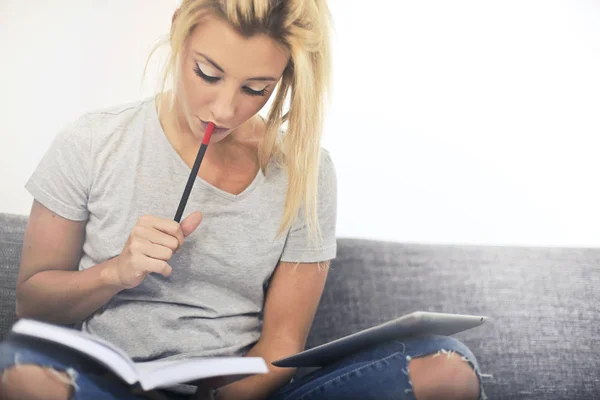 Mujer rubia estudiando en el sofá —  Fotos de Stock