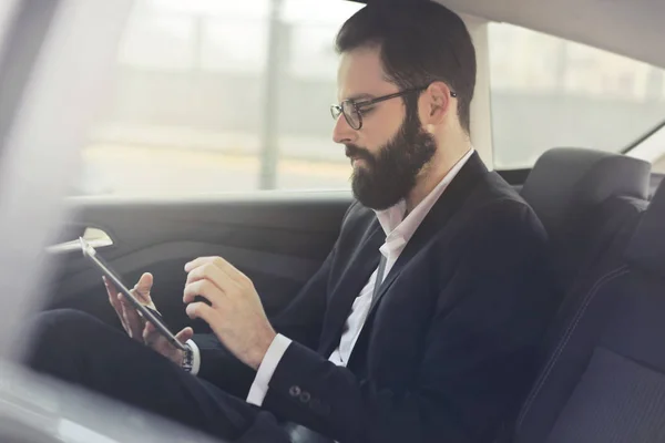 Businessman with phone in the car — Stock Photo, Image