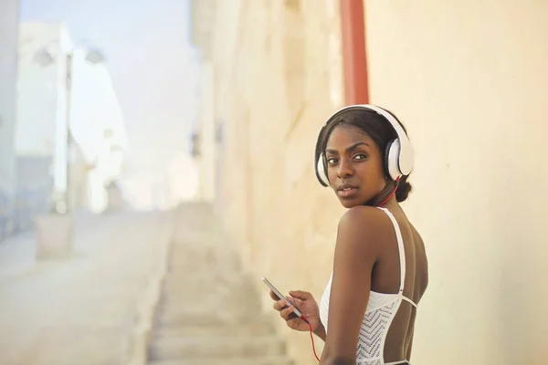 Jeune femme noire avec écouteurs — Photo