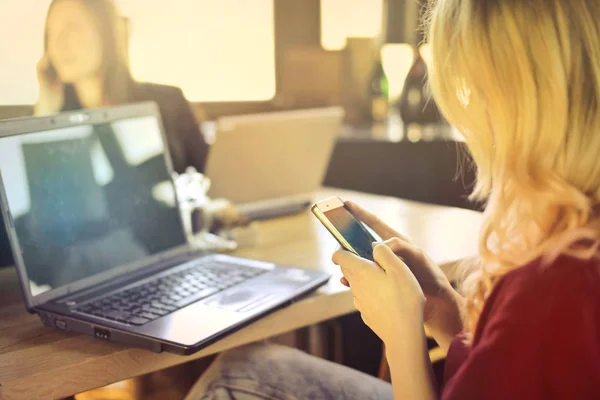 Blond kobieta za pomocą jej telefon i laptop — Zdjęcie stockowe