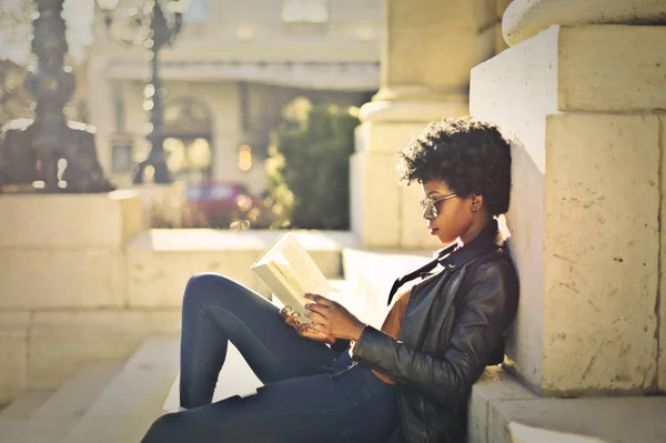 Joven mujer negra leyendo en la ciudad —  Fotos de Stock