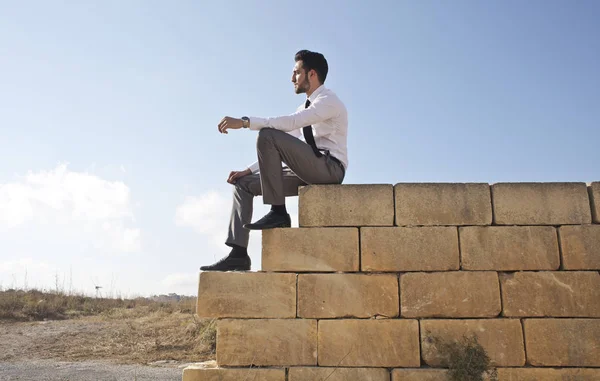 Бізнесмен сидить на стіні — стокове фото