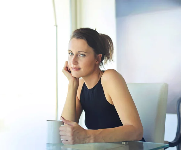 Брюнетка жінка з кави, сидячи за столом — стокове фото