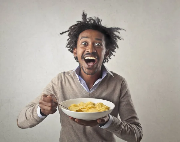 Emocionado hombre negro comiendo de cuenco —  Fotos de Stock