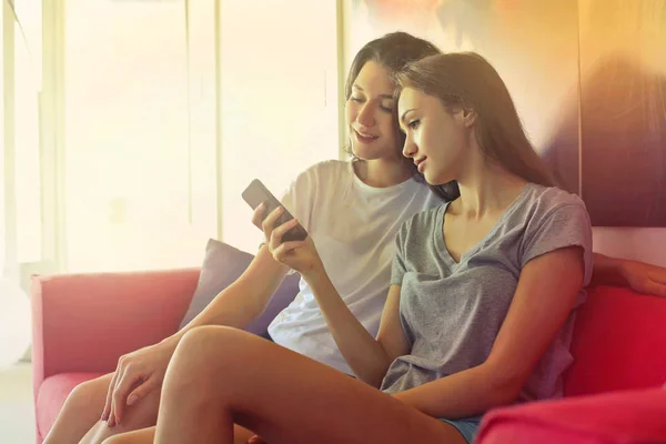 2 jonge meisjes die kijken naar telefoon — Stockfoto