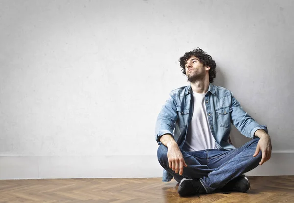 Hombre sentado en una habitación vacía —  Fotos de Stock