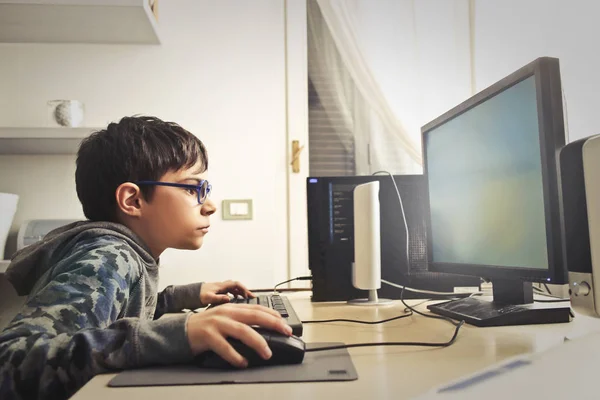 Liten unge spelar på datorn — Stockfoto