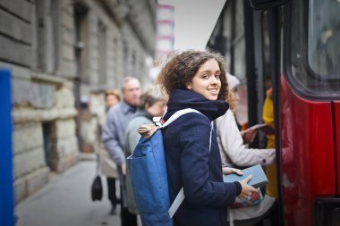 Bir otobüs yakınındaki bir sırt çantası ile kız