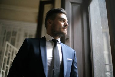 işadamı bir pencereden dışarı bakıyor 