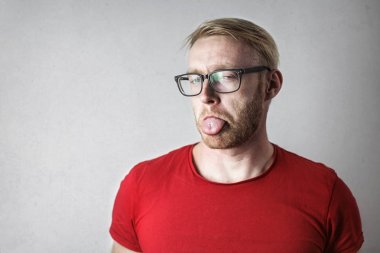 Dilini gösterilen beyaz bir adam portresi 