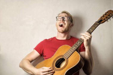 Gitar çalan ve şarkı söyleyen adam 