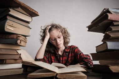 Okuyan adam kitaplar tarafından çevrili