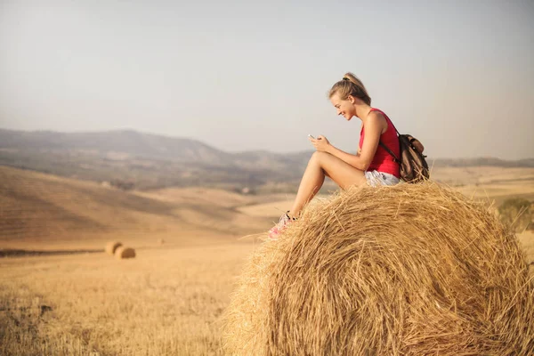 Mädchen Sitzt Auf Einem Heuballen Der Natur Und Benutzt Dabei — Stockfoto