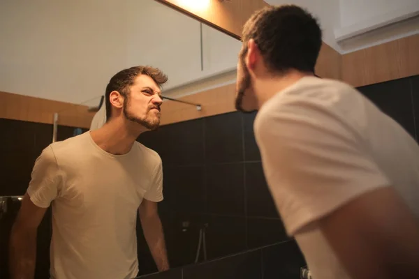 男人在镜子前看着他的胡子 — 图库照片