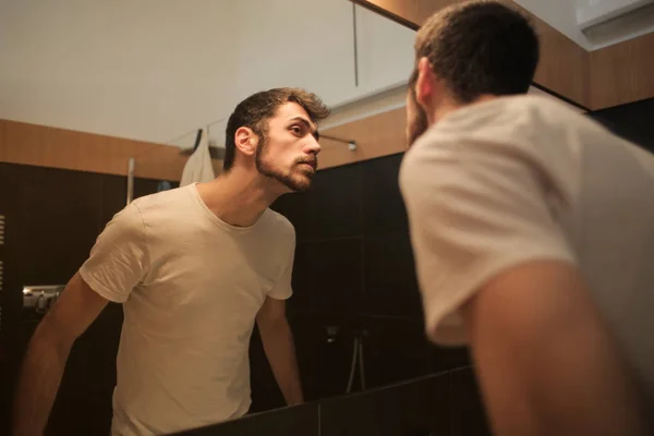 Mann Vor Einem Spiegel Und Blickt Auf Seinen Bart — Stockfoto