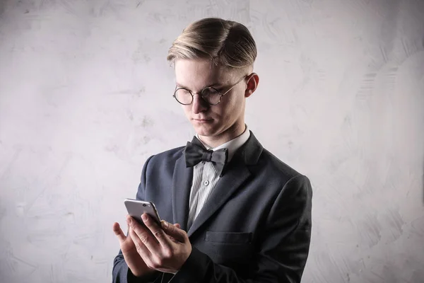 Πορτρέτο Ενός Νεαρού Κομψό Γυαλιά Χρησιμοποιώντας Ένα Smartphone — Φωτογραφία Αρχείου