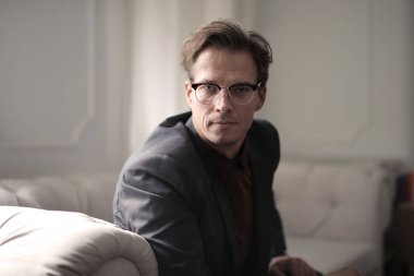 Zarif kanepede oturan beyaz iş adamı 